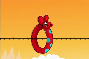 Anillo rojo con cabeza de ratón y lunares azules sobre una cuerda en un fondo naranja