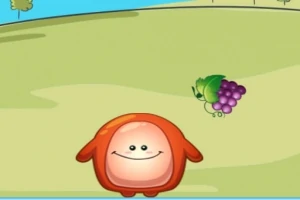 Personaje rojo con forma redonda sonríe en un campo verde con uvas en el suelo