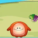 Personaje rojo con forma redonda sonríe en un campo verde con uvas en el suelo