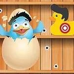 Pájaro azul emergiendo de un huevo entre dos patitos de goma con sombreros y objetivos en una pared de madera con agujeros de bala