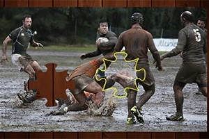 Jugadores de rugby compiten en un campo lodoso con piezas de rompecabezas superpuestas en la imagen