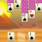 Cartas de juego en un escenario desértico con pirámides al fondo y un sol brillante